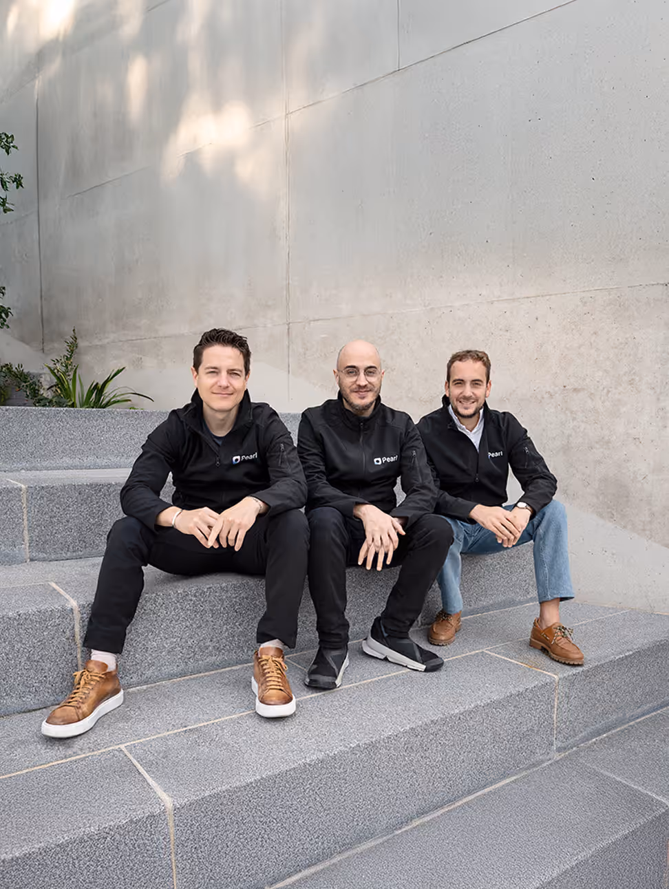 The three Pearl co-founders sitting on concrete steps